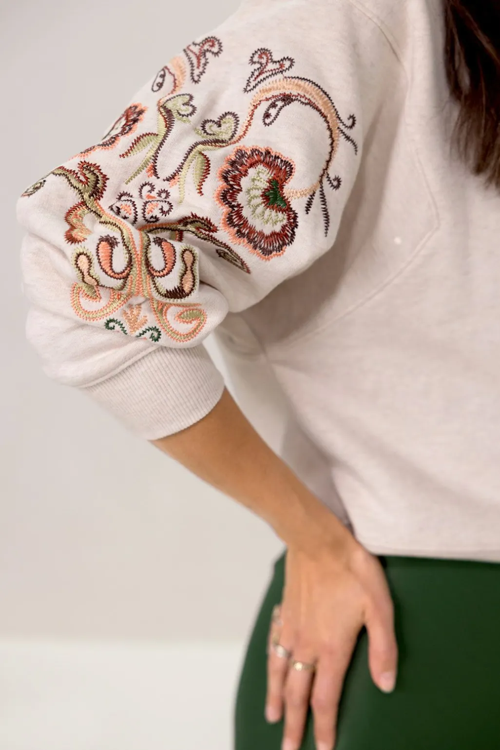 Beige sweater met geborduurde mouw