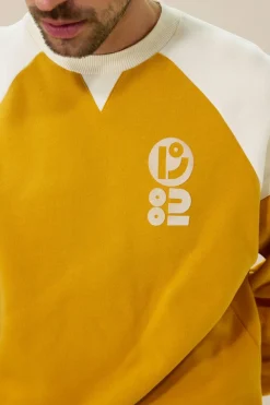 Donkergele sweater met artwork
