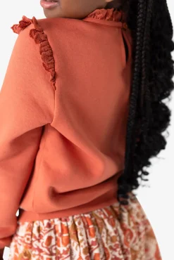 Oranje sweater met ruffle details