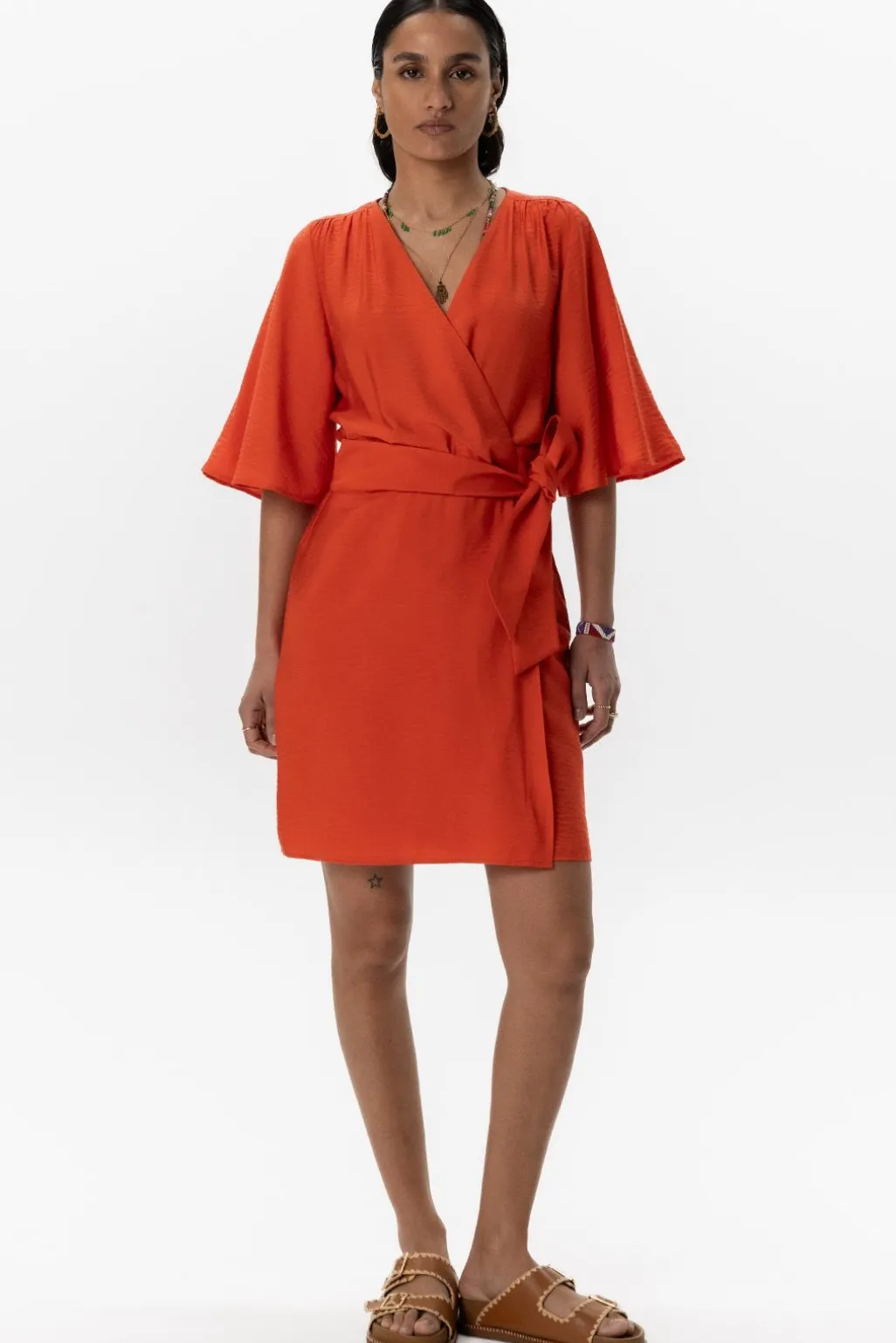 Warm oranje overslagjurk met fladdermouwen