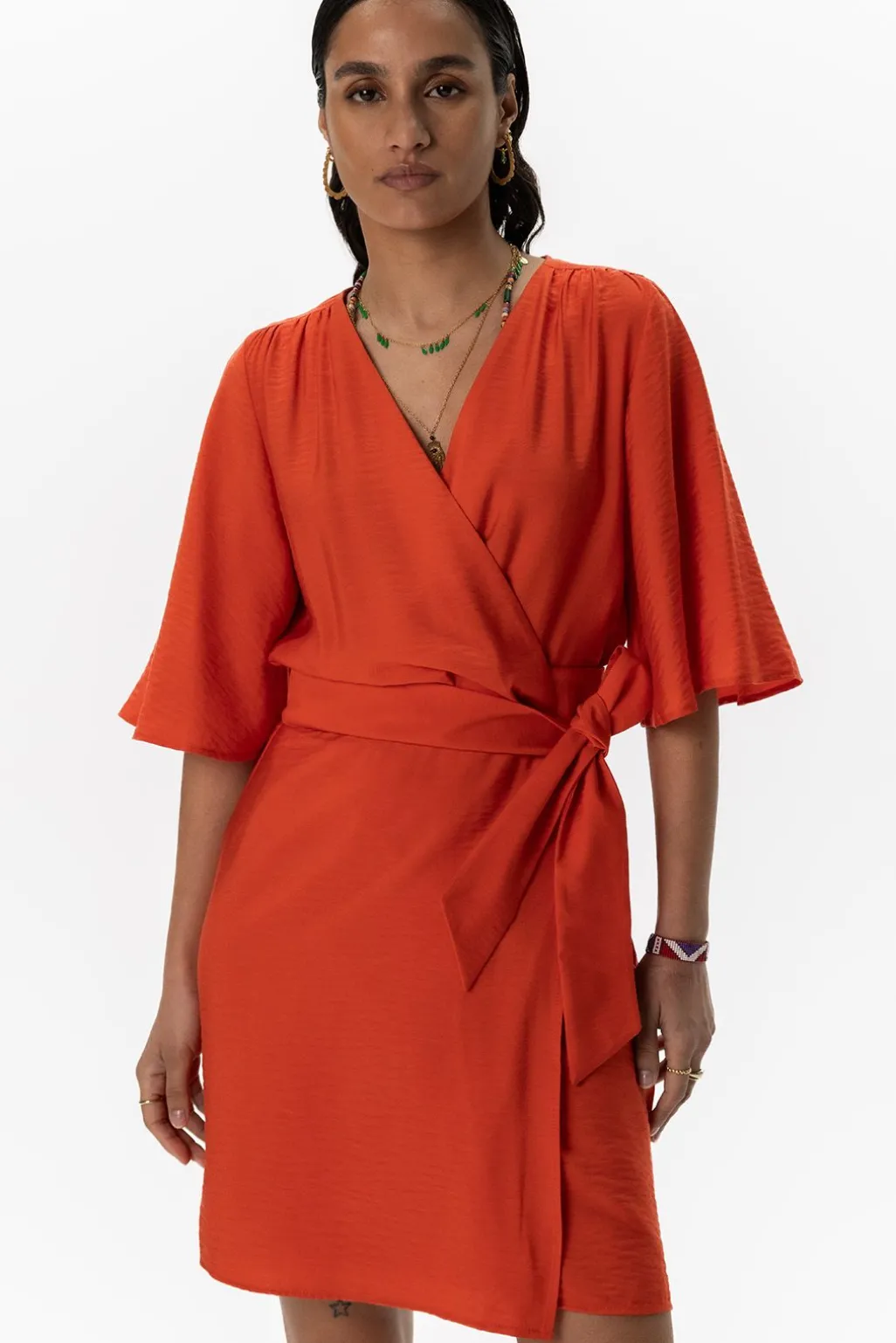 Warm oranje overslagjurk met fladdermouwen