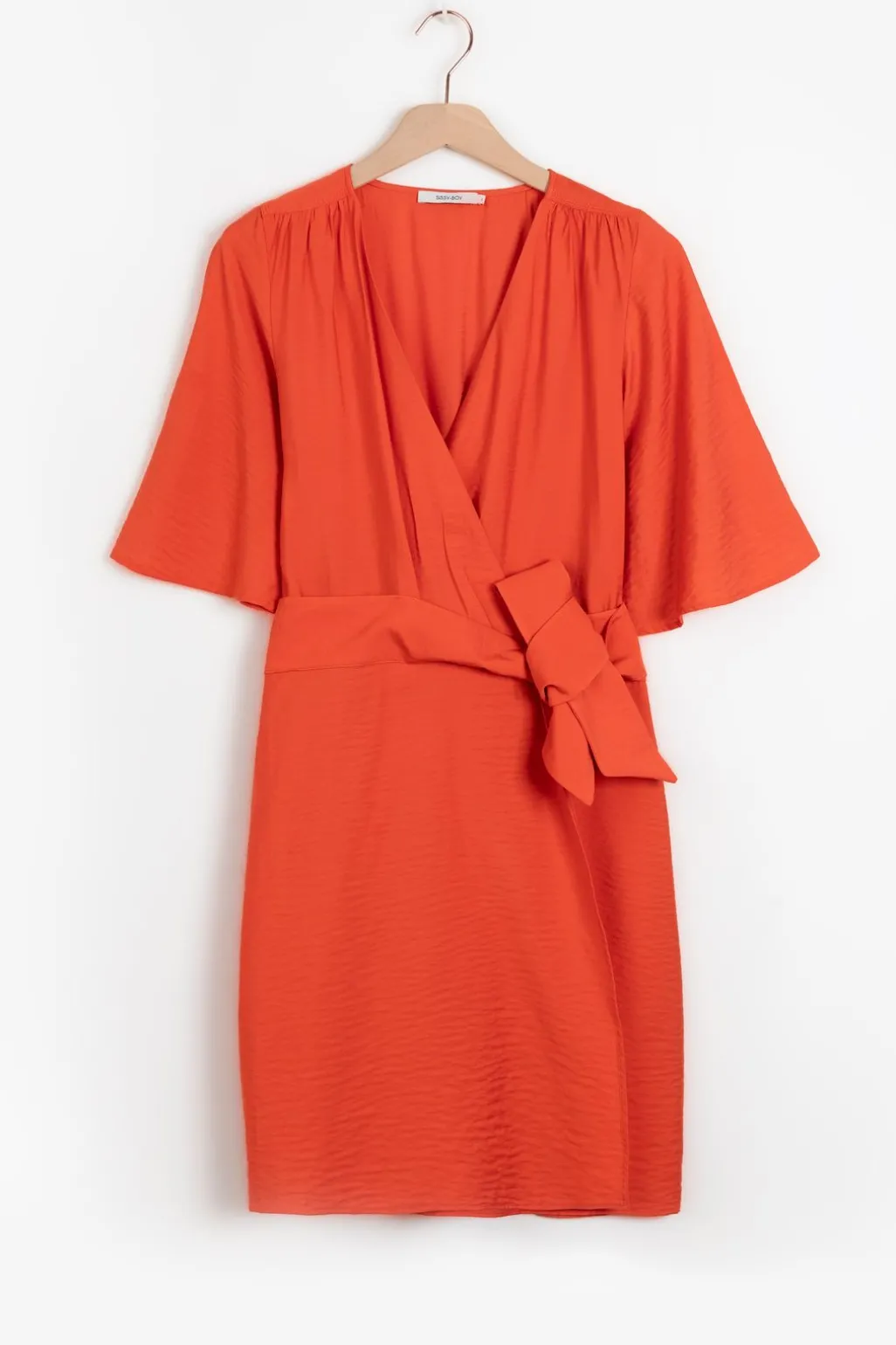 Warm oranje overslagjurk met fladdermouwen