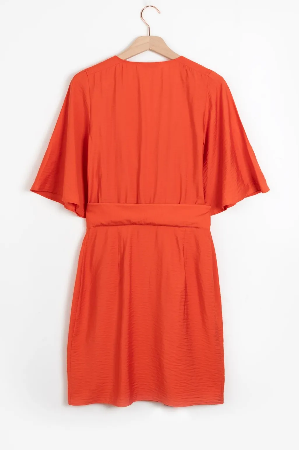 Warm oranje overslagjurk met fladdermouwen